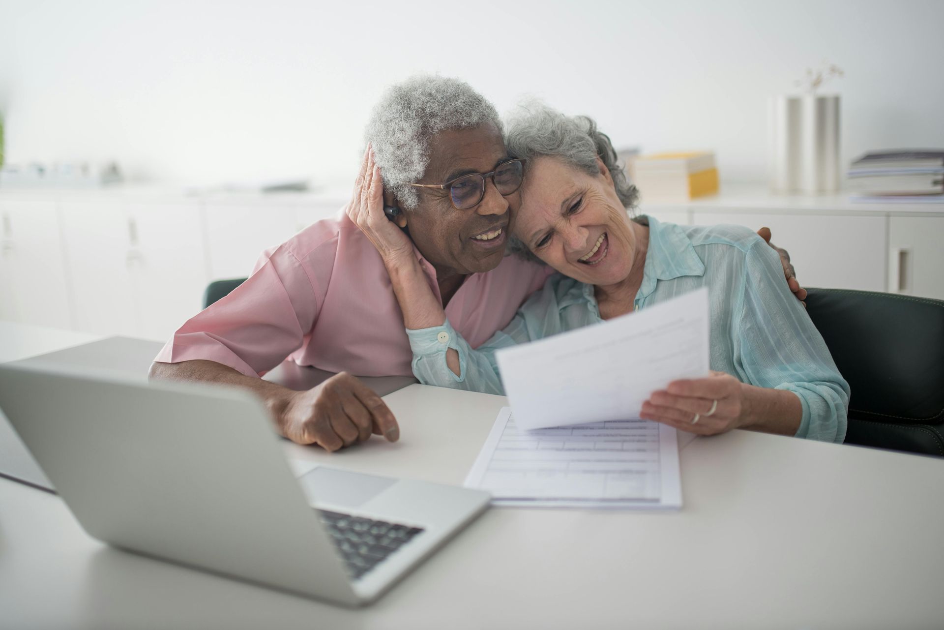 An older couple reading through their insurance policy documents together at home.